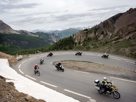 col d'izoard, france, 10 june 2018: group of men on motorcycle reaches col d'izoard in the french alps