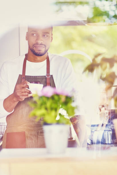 istock Black bearded coffee seller pouring coffee. 995658246