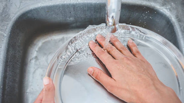 istock Close-up of hands wash utensils. 995681498