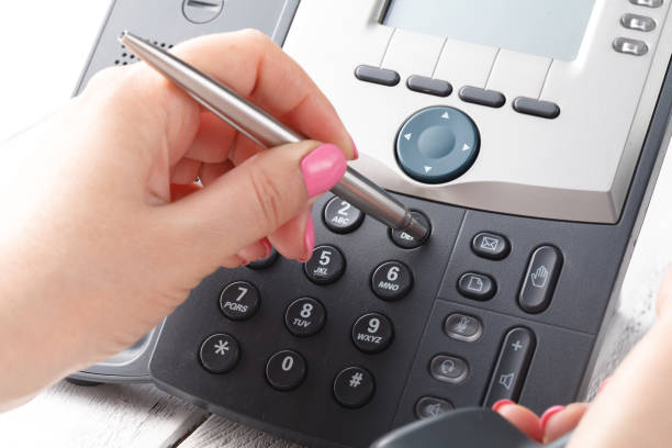 istock Female hand holding phone receiver and dialing number 995687154