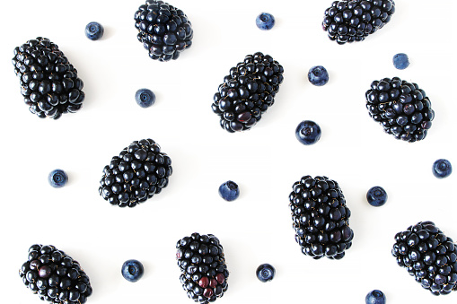 Styled stock photo. Summer healthy fruit composition with juicy blackberries and blueberries isolated on white table background. Food pattern. Empty space, closeup Flat lay, top view.
