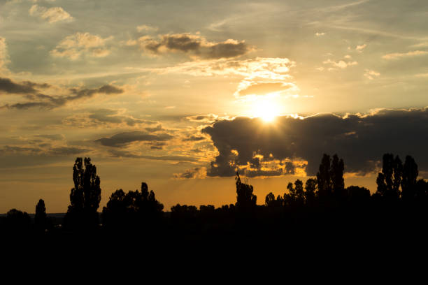 istock evening sunset over the trees among the clouds 995687446