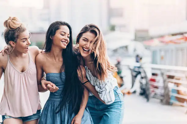 Photo of Three young women walking and laughing