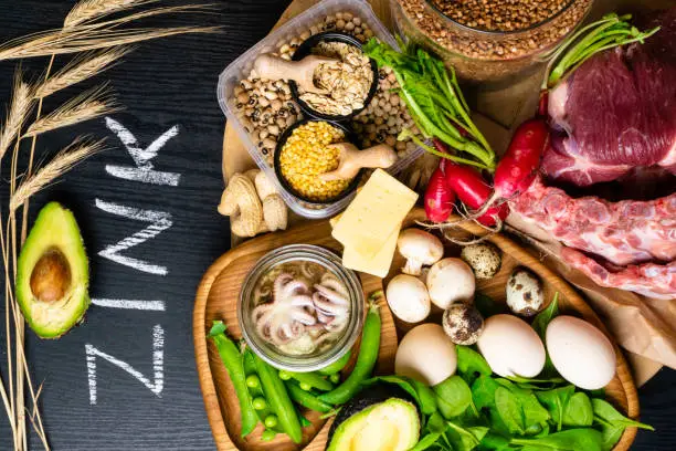 Foods Highest in Zinc as octopus in oil, beef, buckwheat, yellow cheese, spinach, avokado,pea, mushrooms, bean, radishes eggs with inscription Healthy diet food Top view