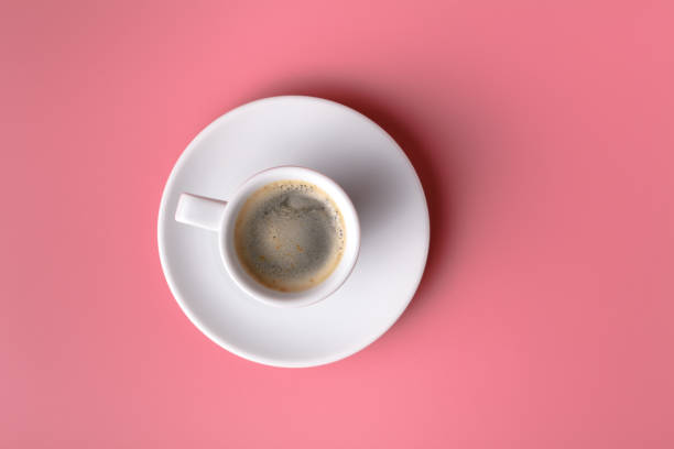 istock One small cup of coffee on pink background 995695260