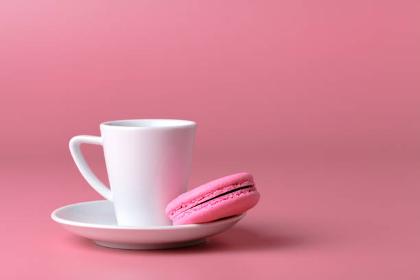 istock One pink macaroon with cup of coffee 995695982