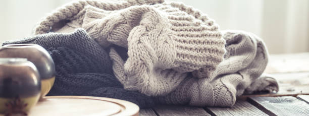 istock Knitted sweaters on a wooden background in the interior 995696570