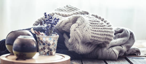 istock Knitted sweaters on a wooden background in the interior 995696598