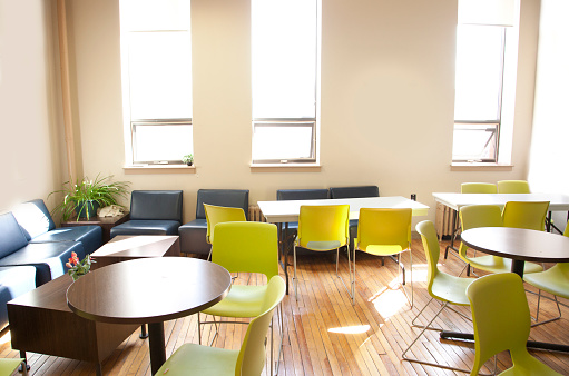 A brightly lit space with empty tables and chairs, ready for office employees or students to meet and eat