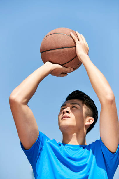 istock young asian basketball player making a jump shot 995701278