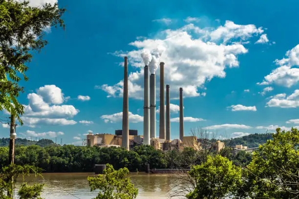 A distant power plant along the river with blue sky and white clouds