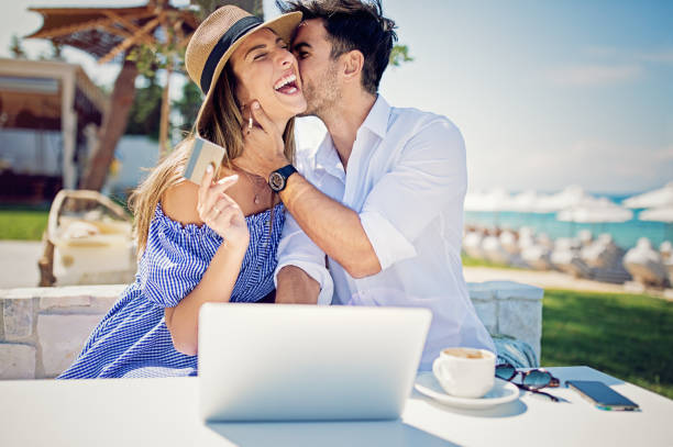 istock Couple is shopping online/making reservation on the beach 995716954