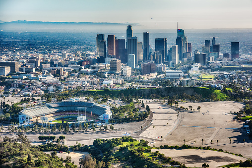 Los Angeles, United States - March 28, 2018:  Chavez Ravine, the home of Dodger Stadium and the Los Angeles Dodgers Major League Baseball team with a view of the downtown LA skyline in the background shot from an altitude of about 1500 feet during a helicopter photo flight.
