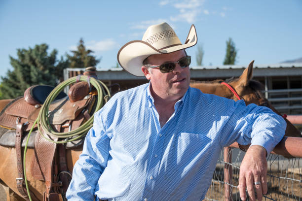 istock Cowboy Leans on Fence and Listens 995727984