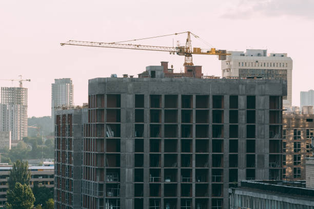 istock Construction of a high-rise building with a crane. Building construction using formwork. The construction crane and the building against the blue sky. 995730748