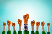 India national flag pattern on leader's fist isolated (clipping path) on blue mint sky for Human equal rights, labor day concept