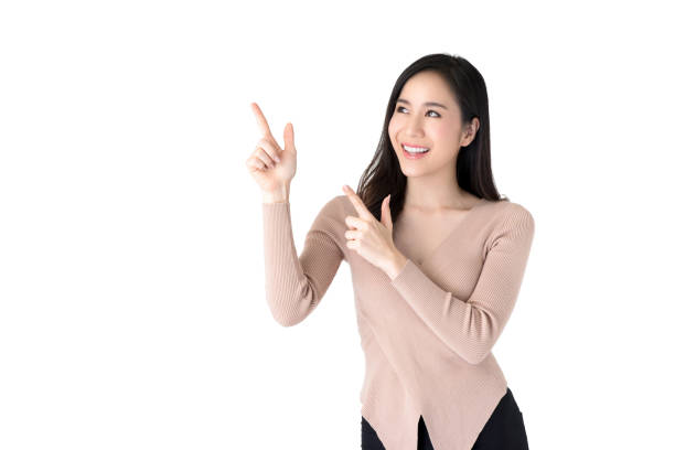 istock Beautiful young Asian woman pointing hands to empty space aside 995746402