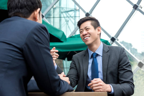 istock Young Asian business partners talking at cafe 995746558