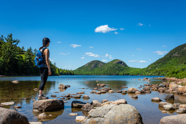 Backpacker enjoying the view of Jordan Pond in Acadia National Park A female hiker exploring Jordan Pond in Acadia National Park, Maine. acadia national park maine stock pictures, royalty-free photos & images