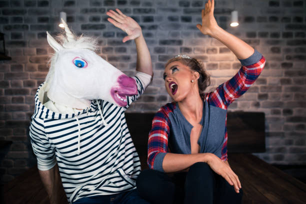 istock Happy young woman with funny man in comical mask 995771490