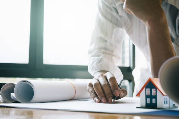 istock Architect or engineer working in office with blueprints,engineer inspection in workplace for architectural plan,sketching a construction project ,selective focus,Business construction concept. 995778892