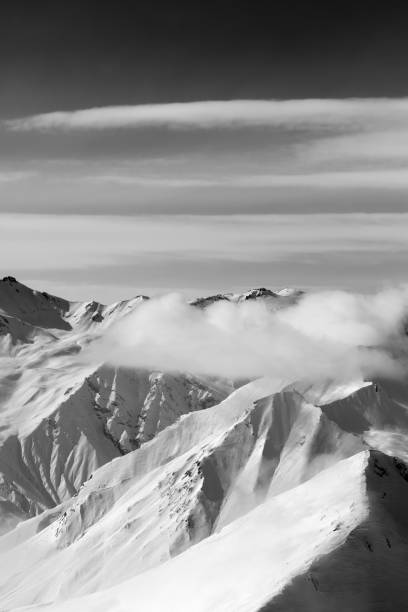 istock Black and white snow mountains in clouds 995779052