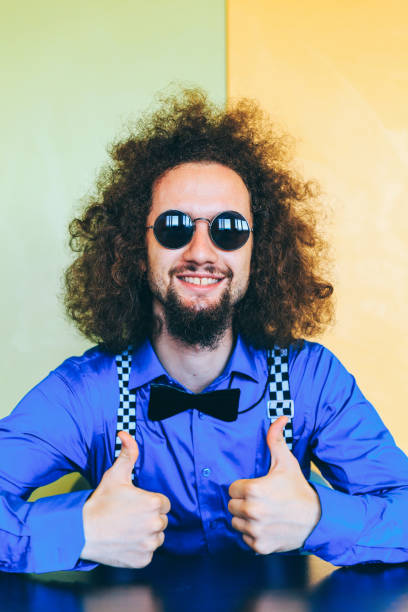 istock Man with curly hair and bow tie, thumbs up 995782366
