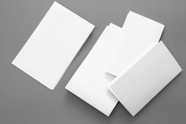 istock Blank portrait A4. brochure magazine isolated on gray, changeable background / white paper business card isolated on gray 995794526