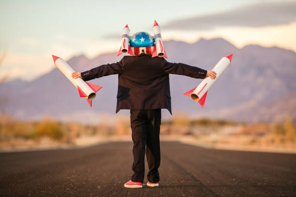 istock Young Business Boy in Helmet Holding Rockets 995808194