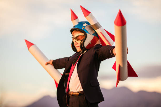 Young Business Boy in Helmet Holding Rockets