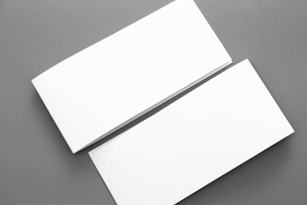 istock Blank portrait A4. brochure magazine isolated on gray, changeable background / white paper business card isolated on gray 995856920