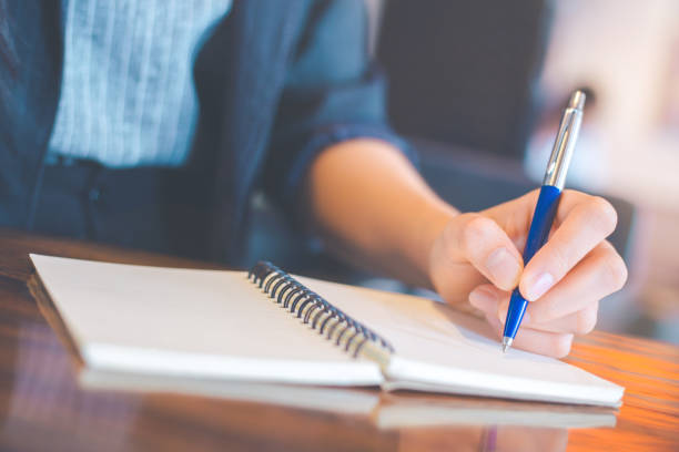 istock Business woman writing on a notebookwith a pen in the office 995879512
