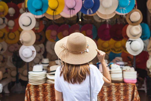 viajero mujer joven en busca de sombrero en el mercado local en tailandia - selling merchandise craft thailand fotografías e imágenes de stock