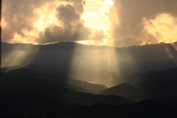 istock Dramatic god lights passing through clouds and shining on mountain ranges. warm light shower. God hope and dream concept 995883356