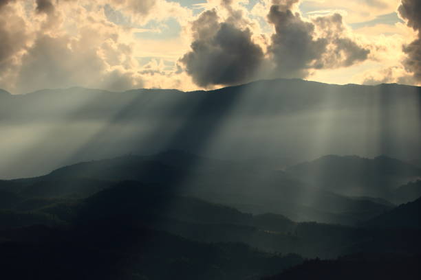 istock Dramatic god lights passing through clouds and shining on mountain ranges. warm light shower. God hope and dream concept 995883490