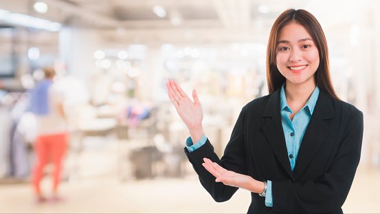 Portrait of Asian beautiful smiling businesswoman customer support on blurred interior shopping mall background and copy space.Concept business job service.