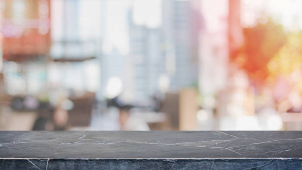 istock Empty black marble stone table top and blurred bokeh cafe and restaurant interior background with vintage filter - can used for display or montage your products. 995887324