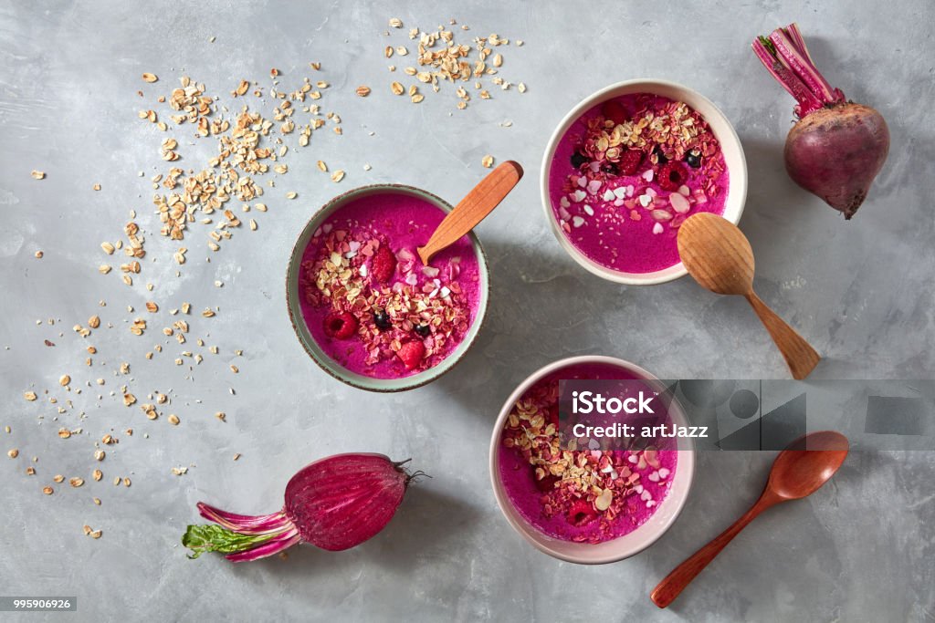 Healthy breakfast bowl with beetroot, oat flakes and berry on stone background, flat lay Superfoods red smoothie bowl with beetroot, oat flakes and raspberries on stone background, flat lay Smoothie Stock Photo