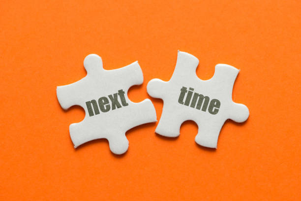 istock Two white details of puzzle with text Next Time on orange background, close up. 995921832