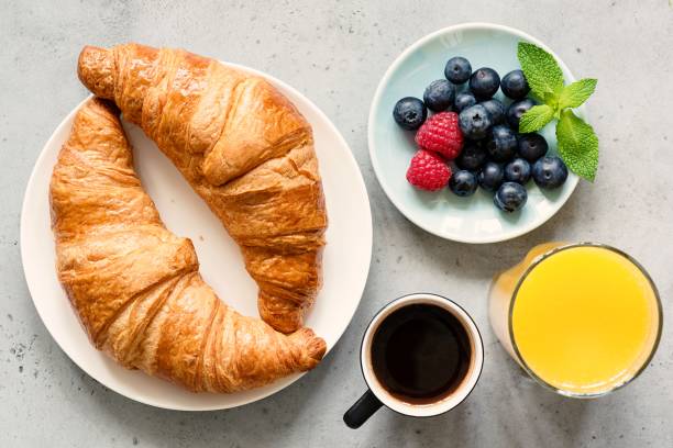 istock Croissant, black coffee, orange juice and fresh berries 995925980