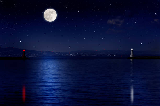 istock Full moon rising over the sea and the lighthouse 995928780
