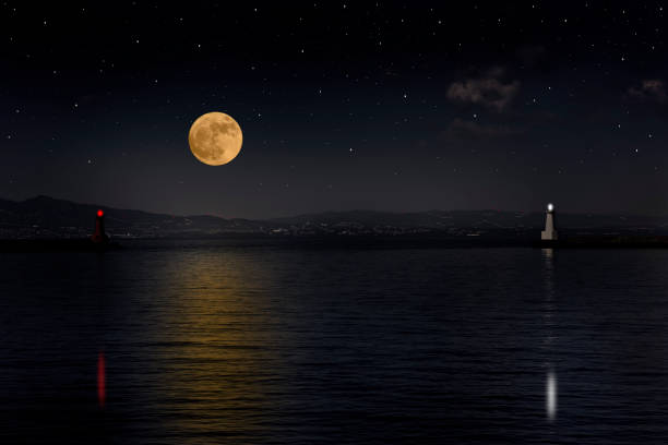 istock Full moon rising over the sea and the lighthouse 995928782