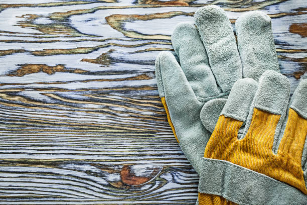 istock Yellow protective gloves on wooden board 995929204