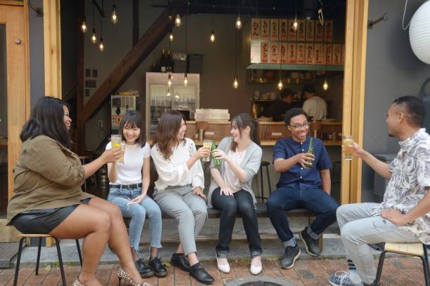 istock Various ethnic young people enjoying drinking together 995932708