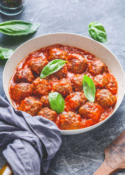 istock Meatballs with tomato sauce and basil in a white iron pan. Modern style. Dinner concept. 995937728