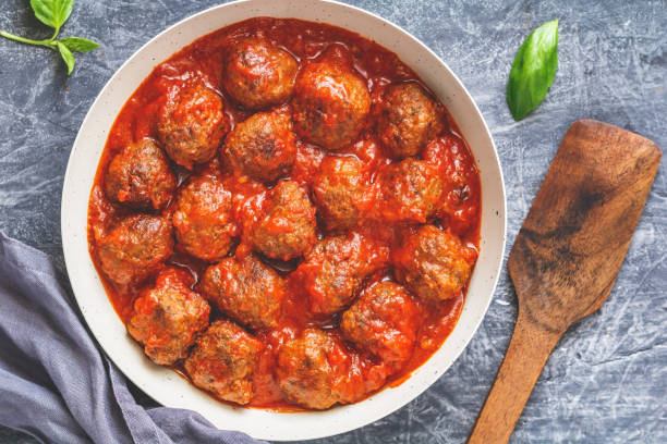 istock Meatballs with tomato sauce in a white iron pan. Modern style. Top view. 995937758