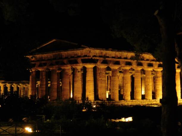 Paestum - View of the Temple of Neptune at night Paestum, Salerno, Campania, Italy - July 1, 2018: Temple of Neptune illuminated in the Archaeological Park of Paestum temple of neptune doric campania italy stock pictures, royalty-free photos & images