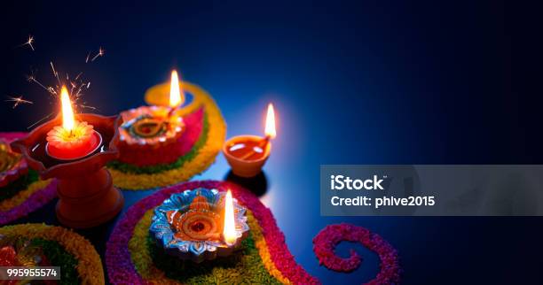 Oil Lamps Lit On Colorful Rangoli During Diwali Celebration Stock Photo - Download Image Now