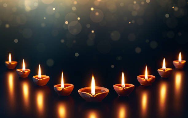 Diya lamps on a reflective base with glittering bokeh Diya lamps on a reflective base with glittering bokeh diwali photos stock pictures, royalty-free photos & images
