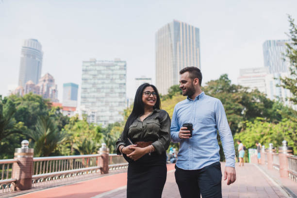istock Two businesspeople taking a break and walking in the park 995955788